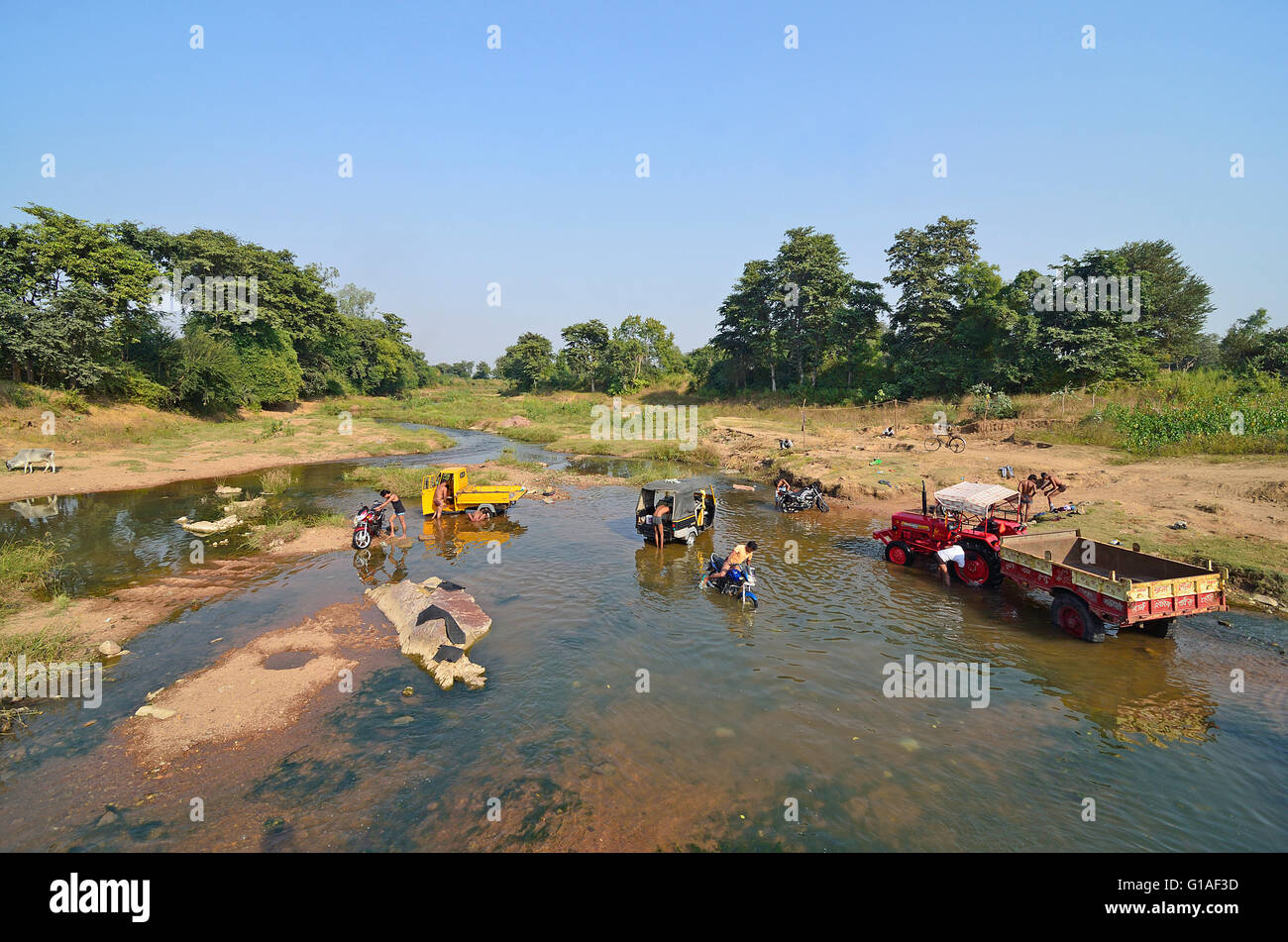 La popolazione locale pulire i loro veicoli in un fiume, Khajuraho, Madhya Pradesh, India Foto Stock