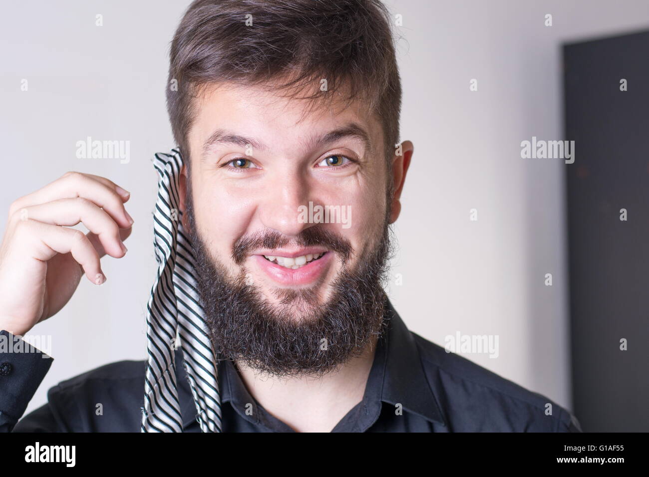 L uomo che sta provando una cravatta a strisce Foto Stock