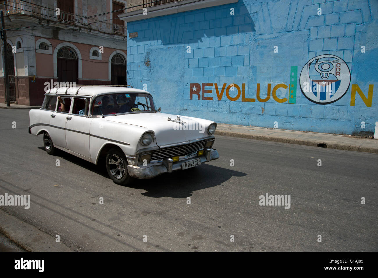 Un vecchio 1950's American classic car passa una rivoluzione pittura murale a Cienfuegos Cuba Foto Stock
