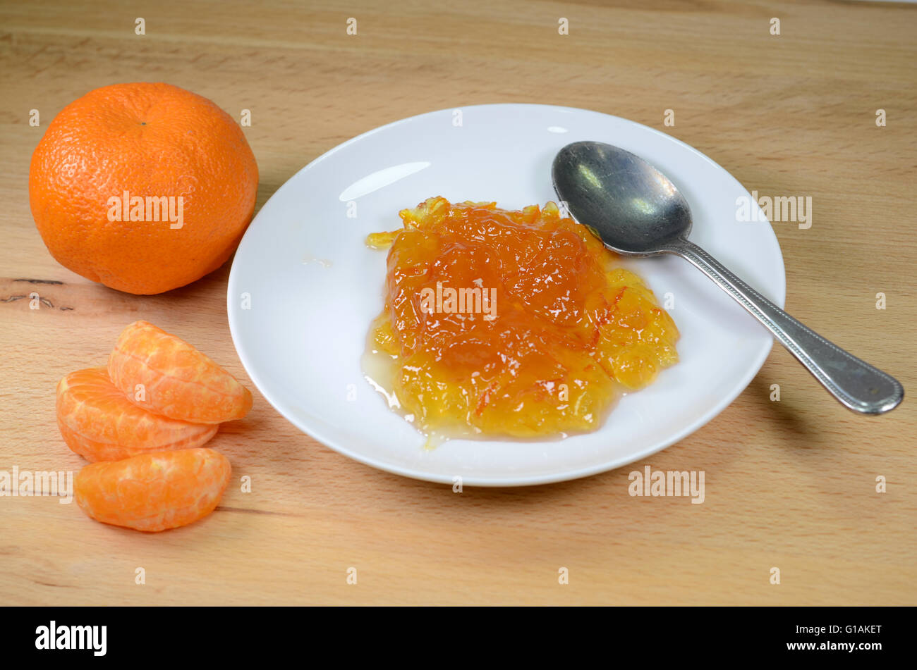 Marmellata di arance con cucchiaio e pezzi di colore arancione. Foto Stock