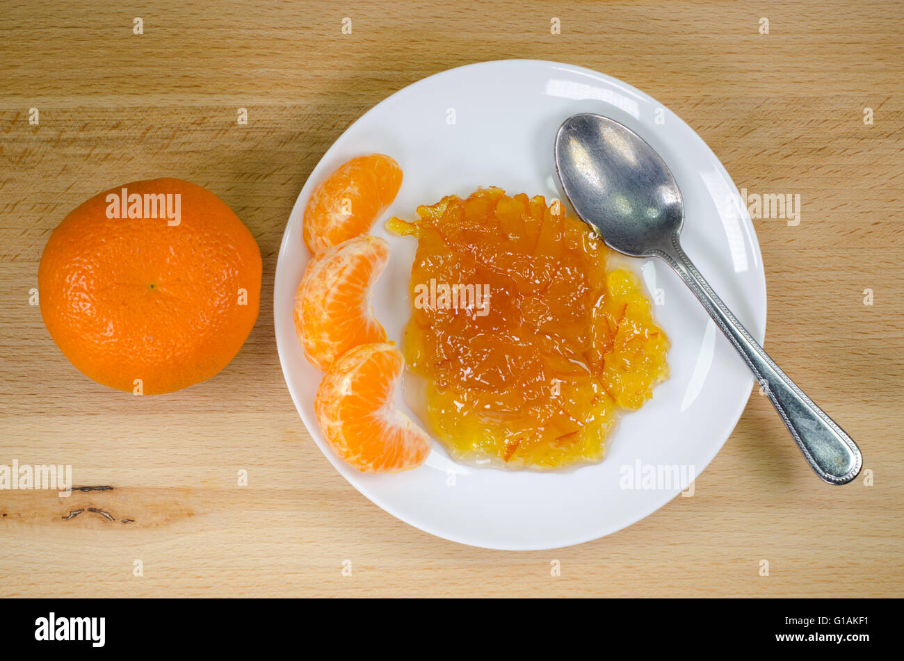 Marmellata di arance con cucchiaio e pezzi di colore arancione dal di sopra Foto Stock