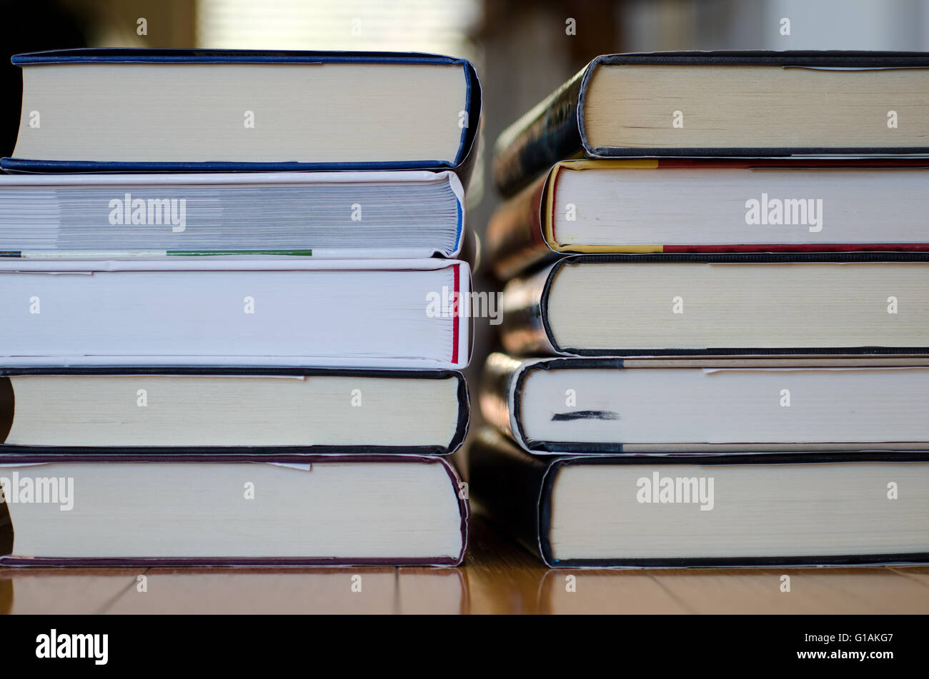 Due pile di libri su uno sfondo di legno Foto Stock