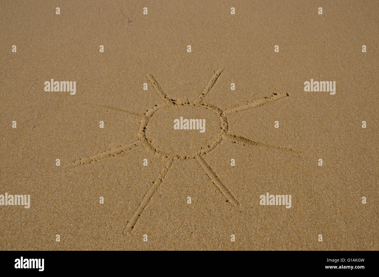 Immagine del sole disegnato in sabbia bagnata Foto Stock