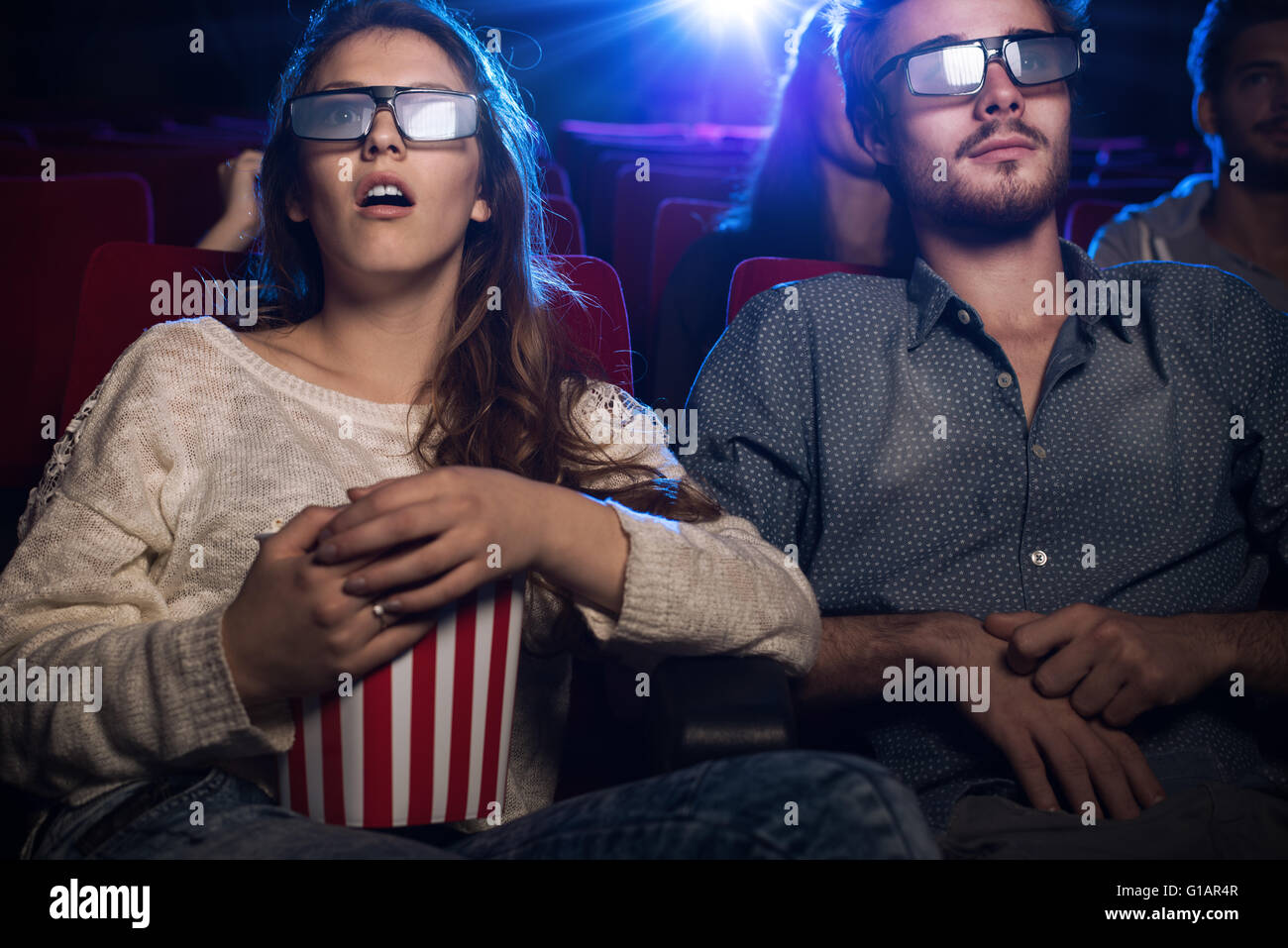 Giovani adolescenti al cinema con gli occhiali e la visione di un film in 3d, è una ragazza mangiare popcorn, intrattenimento e film concep Foto Stock