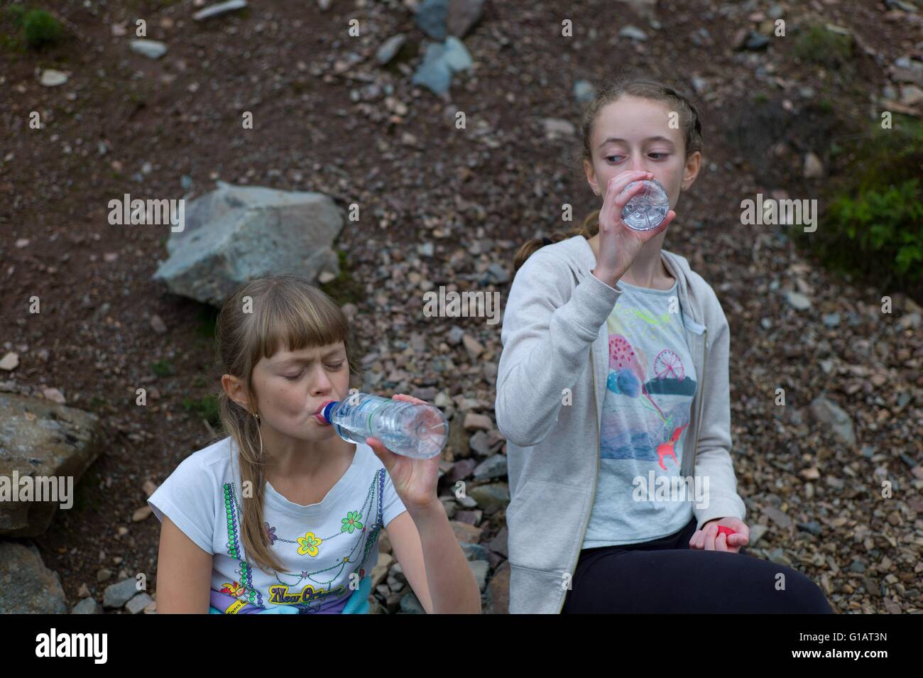 Stanchi i bambini acqua potabile in una passeggiata nel quartiere del lago Cumbria Regno Unito Foto Stock