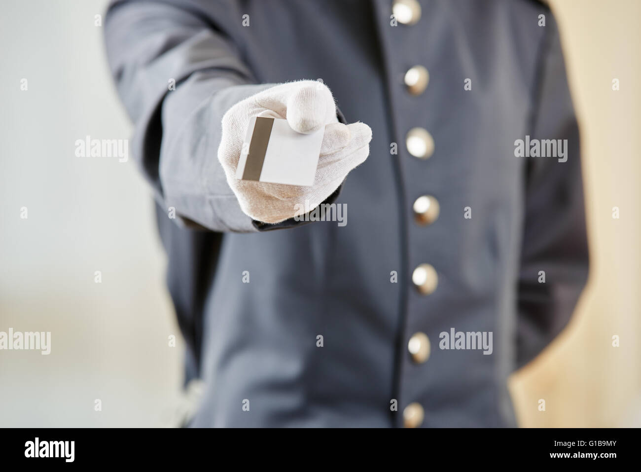 Mano di addetto al ricevimento che offre una carta chiave Foto Stock