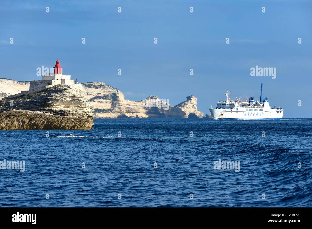 Francia, Corse du Sud, Bonifacio, il collegamento di traghetto per la Sardegna arrivo verso le scogliere calcaree e il faro all'ingresso della grotta Foto Stock
