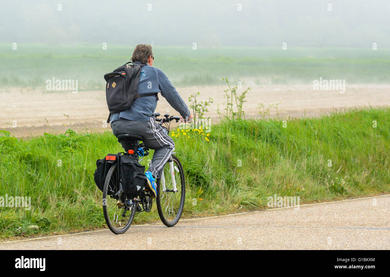 Ciclista in bicicletta da soli su una strada di campagna nel Regno Unito. Uno stile di vita sano. Foto Stock