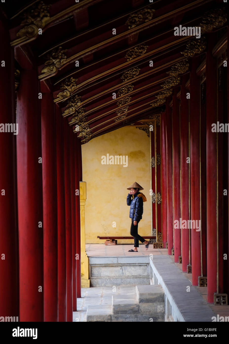 Una signora a piedi attraverso la cittadella imperiale di Hue, Vietnam Foto Stock