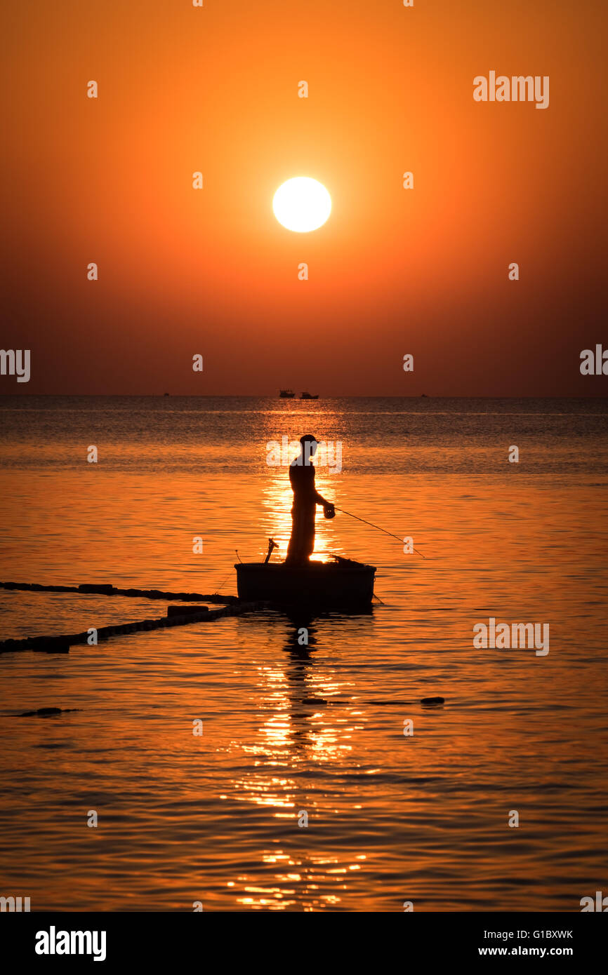 Un uomo la pesca al tramonto nel resort isola di Phu Quoc al largo della costa del sud del Vietnam Foto Stock