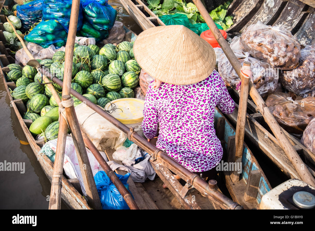 Una donna vendita di cocomeri da la sua barca a Phong Dien Mercato galleggiante sul Can Tho fiume nella regione del Delta del Mekong del Vietnam Foto Stock