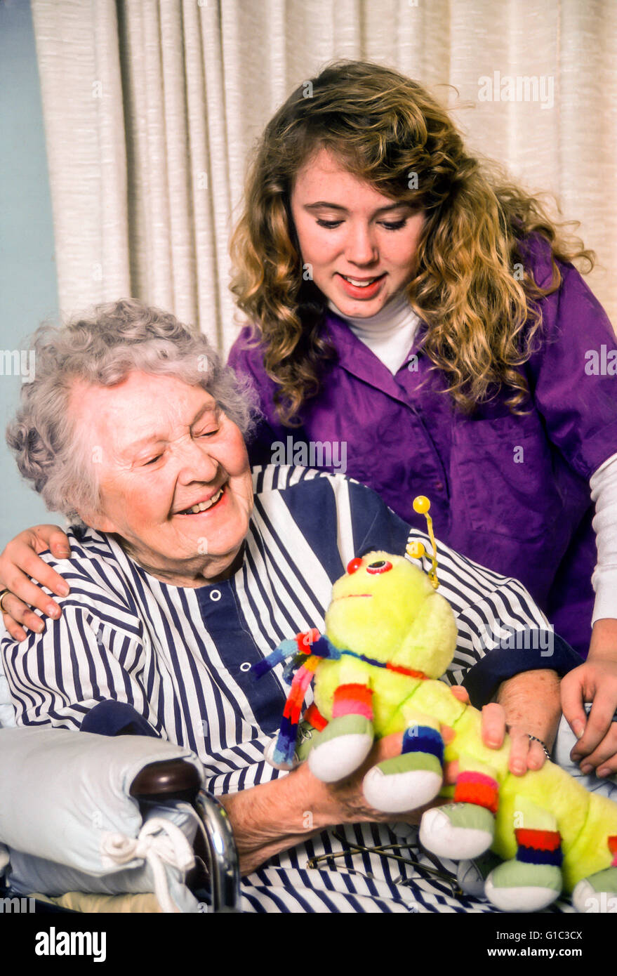 Kid aiutare anziani visita ed appendere fuori con gli anziani anziani disabili handicap donna in cura riabilitativa signor © Myrleen Pearson Foto Stock