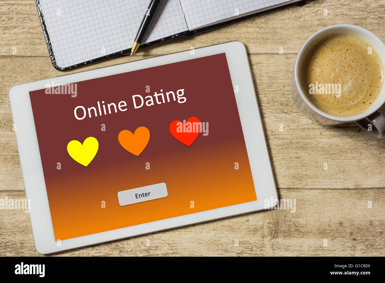 Tablet con Online Dating giacente su una scrivania in legno Foto Stock