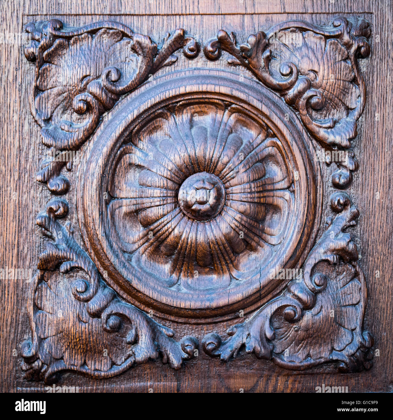 Flower incisa sul portale in legno di una chiesa medievale. Foto Stock