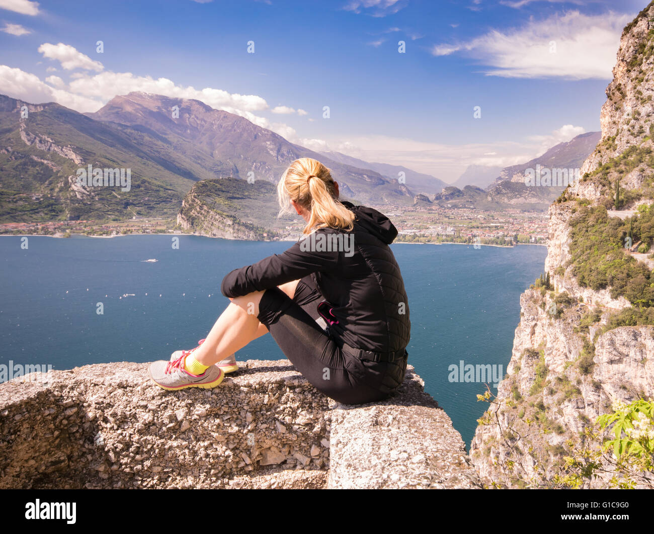 Giovane donna sportivo ammirare il panorama dalla mitica Ponale sentiero in Riva del Garda, Italia. Foto Stock