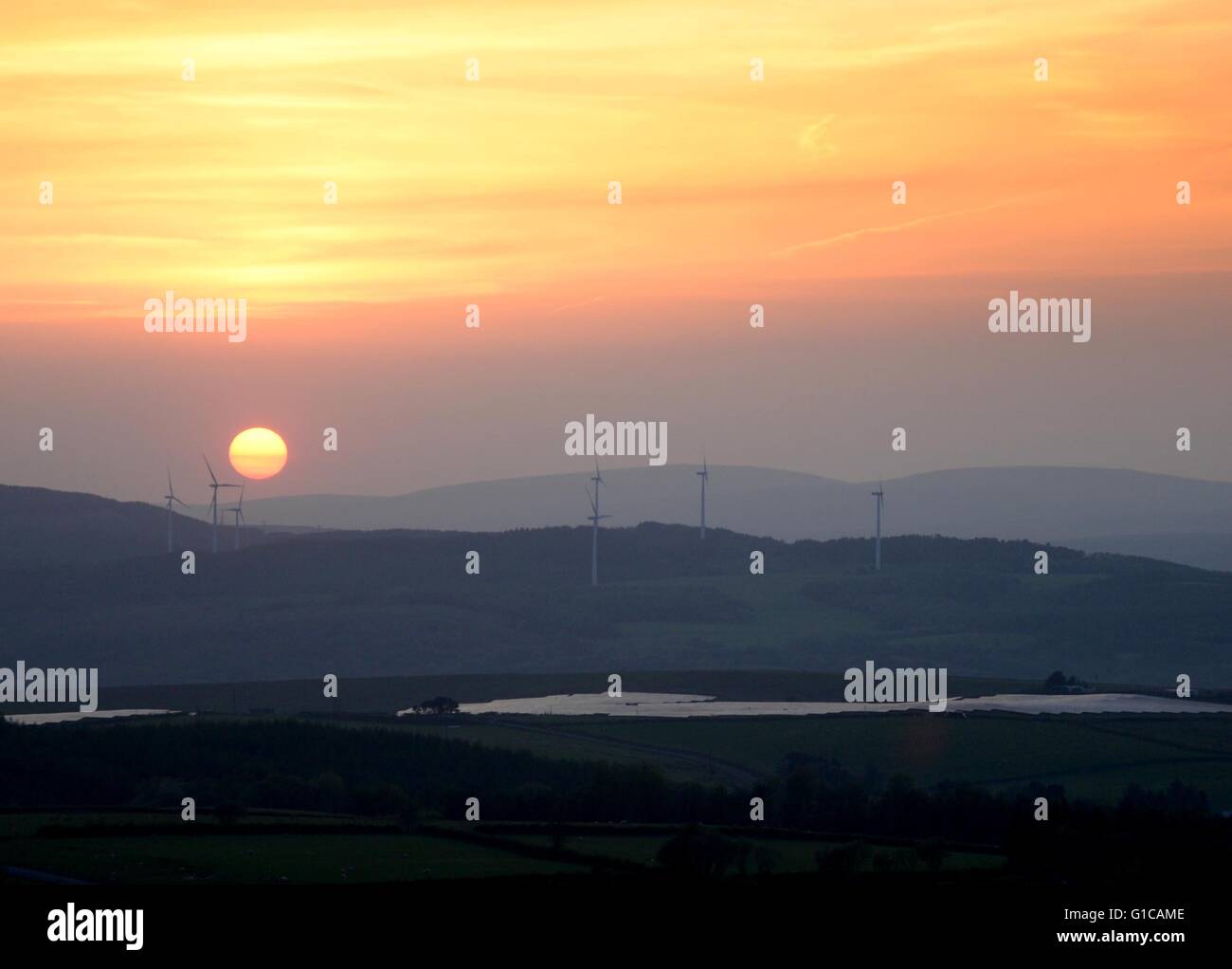 Il sole tramonta su turbine eoliche in Neath Valley, Wales UK Foto Stock