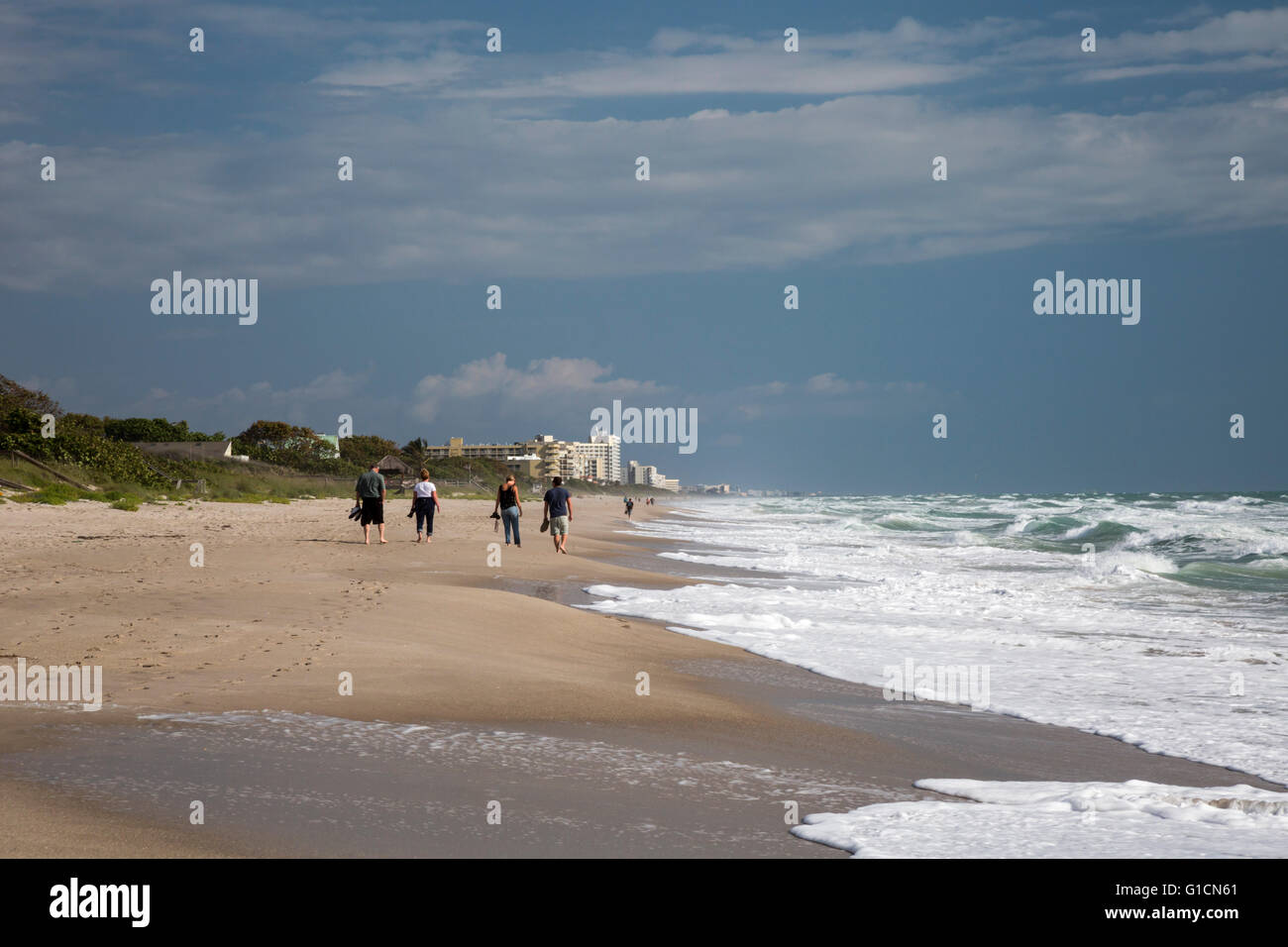 Indialantic, Florida - persone a piedi verso l'alto i condomini e alberghi sulla spiaggia. Foto Stock
