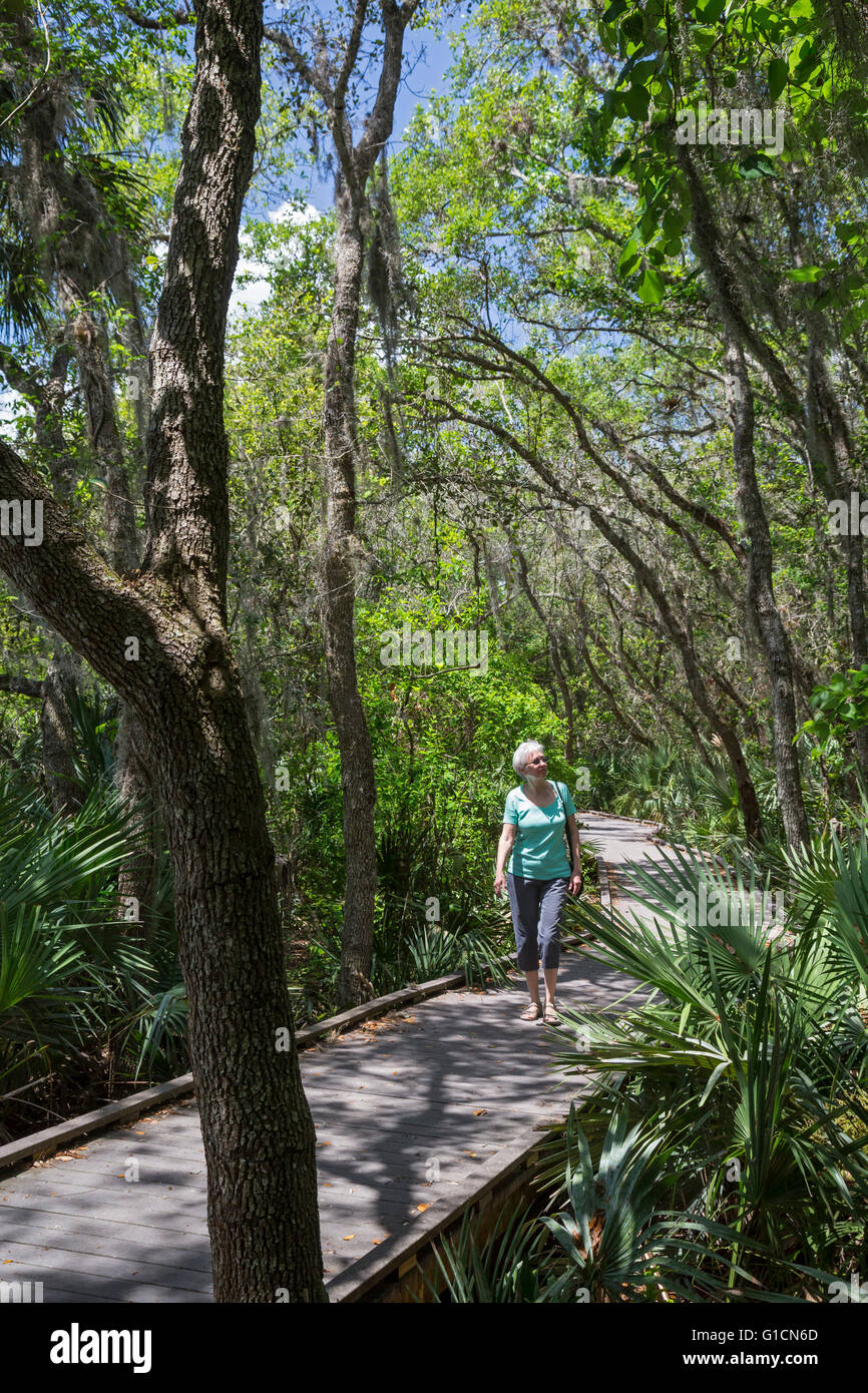 Titusville, Florida - una donna cammina su una passerella trail in Merritt Island National Wildlife Refuge. Foto Stock