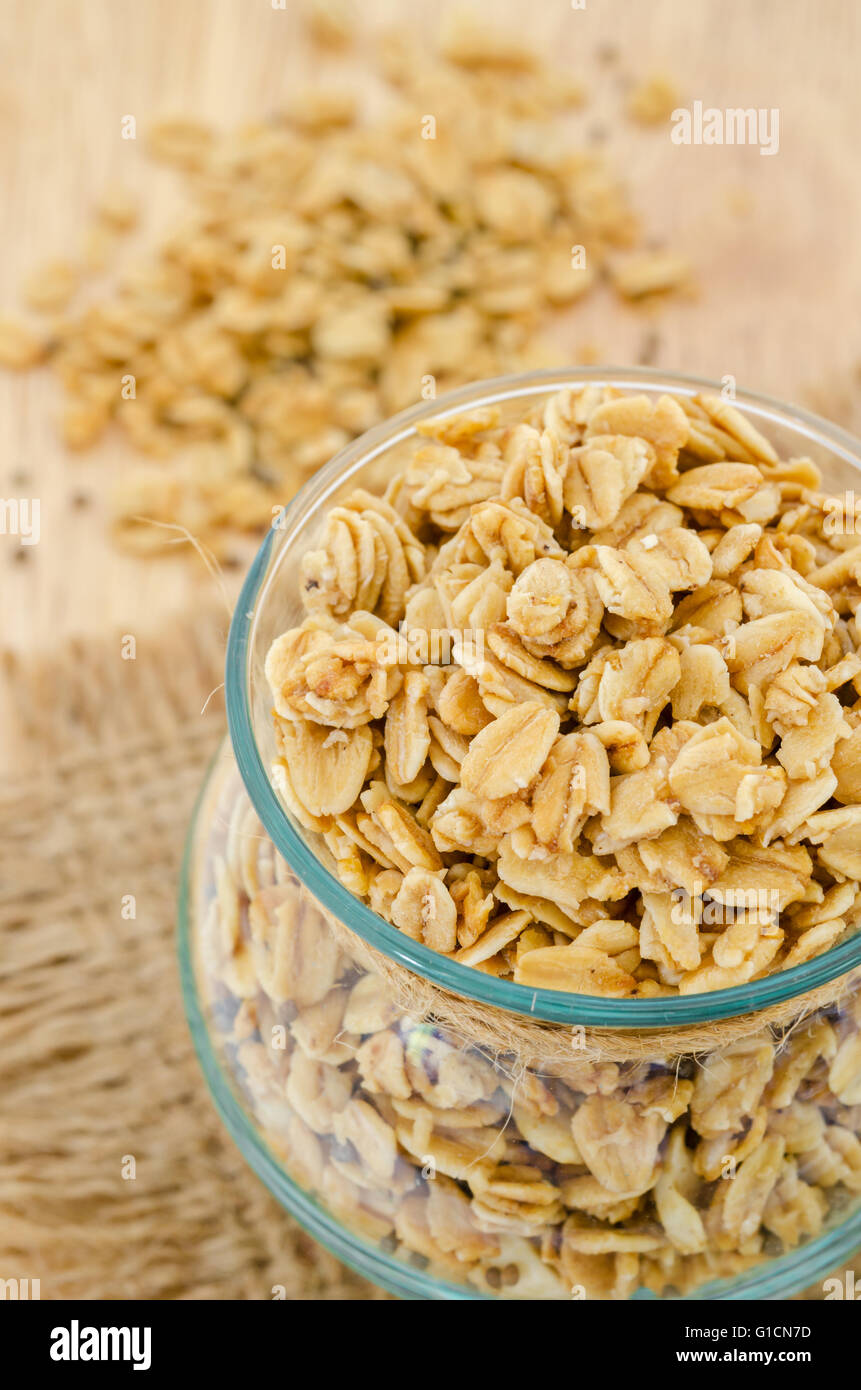 Granola in una bottiglia di vetro su uno sfondo di legno. Foto Stock