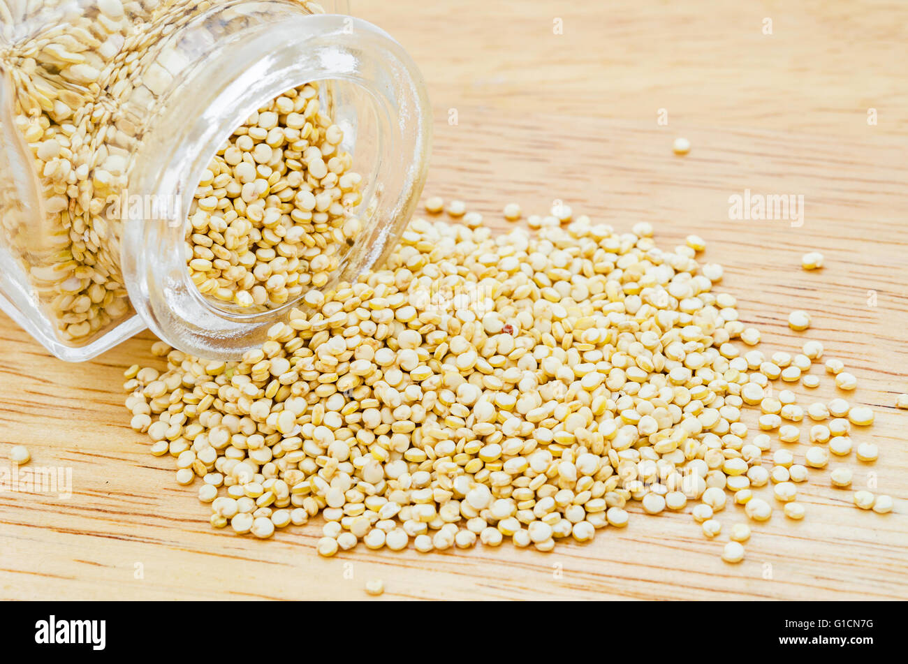 Materie bianco semi di quinoa su sfondo di legno. Foto Stock