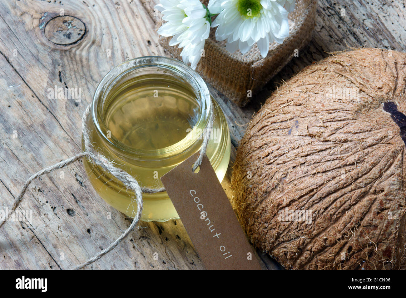 Olio di cocco, olio essenziale di natura, una cura della pelle che di sicuro, ricca vintamin, utilizzare in massaggi presso il centro benessere spa, cosmetici organici su sfondo di legno Foto Stock