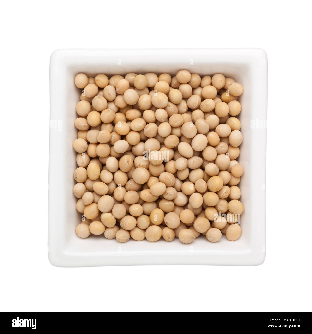 I semi di soia in un recipiente quadrato isolato su sfondo bianco Foto Stock