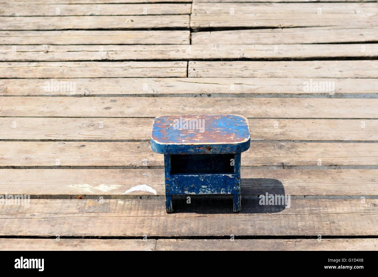 Piccola vecchia blu in legno sedia pesca solo sulla pesca in legno Pier. Croazia, Podgora Foto Stock