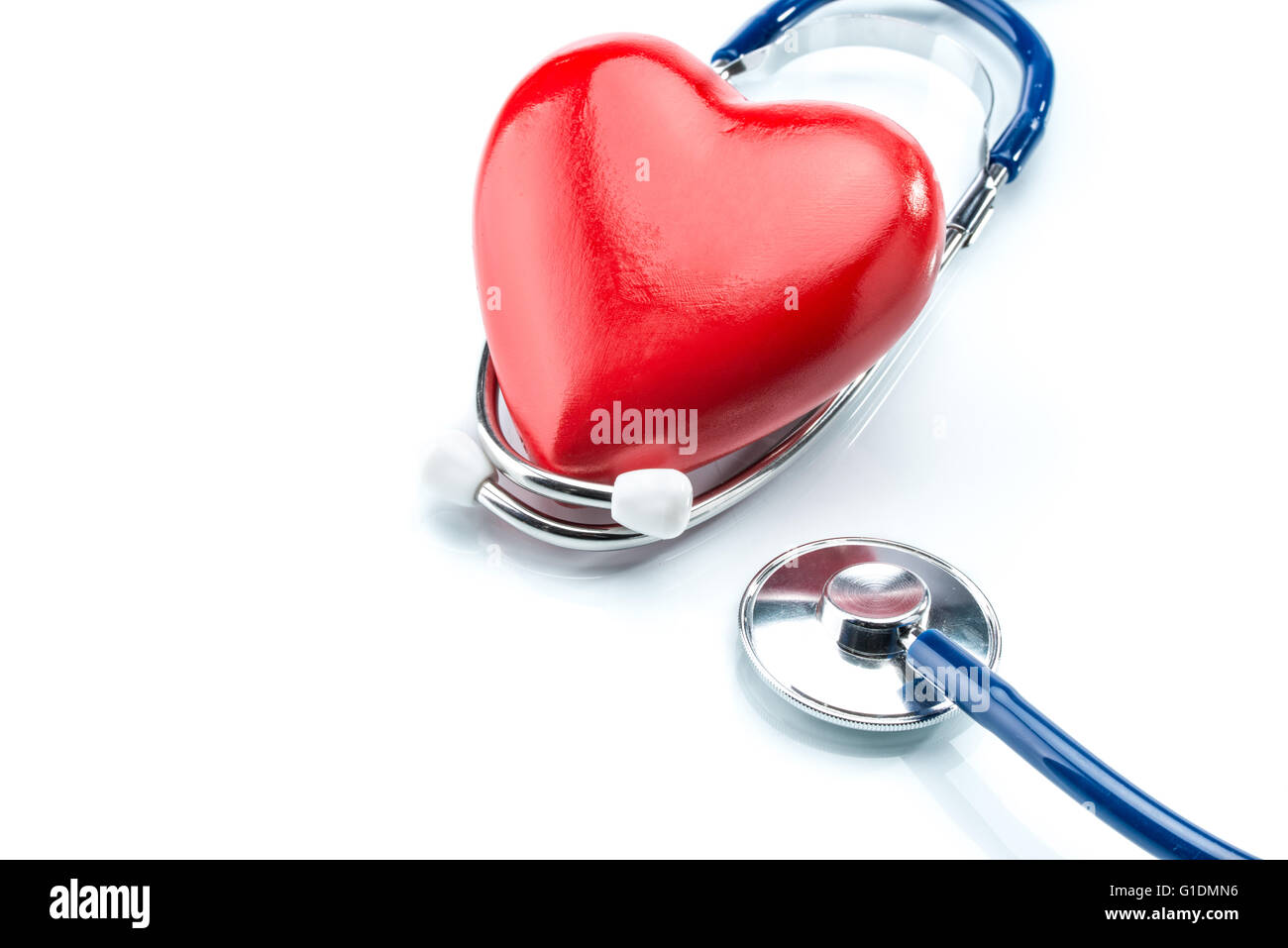 Cuore rosso con uno stetoscopio isolati su sfondo bianco, healthcare Foto Stock