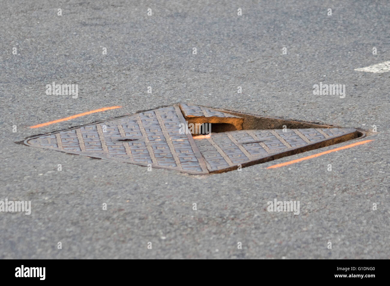 Rotture di ghisa su strada il coperchio di scarico, England, Regno Unito Foto Stock