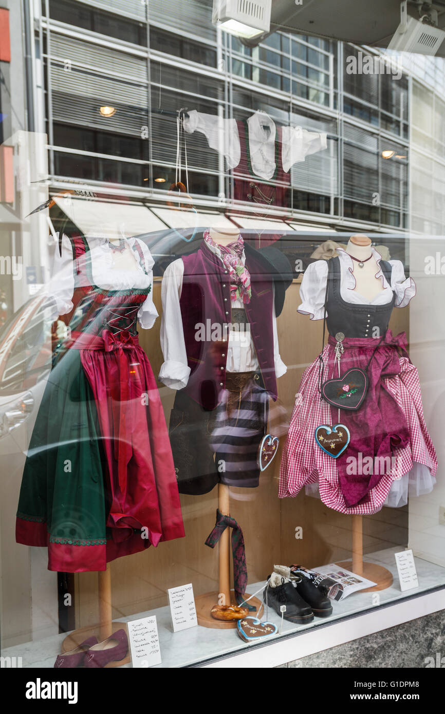 Dirndl vestiti e Lederhose tradizionali bavaresi Tracht esposto in un negozio di finestra a Monaco di Baviera, Germania Foto Stock