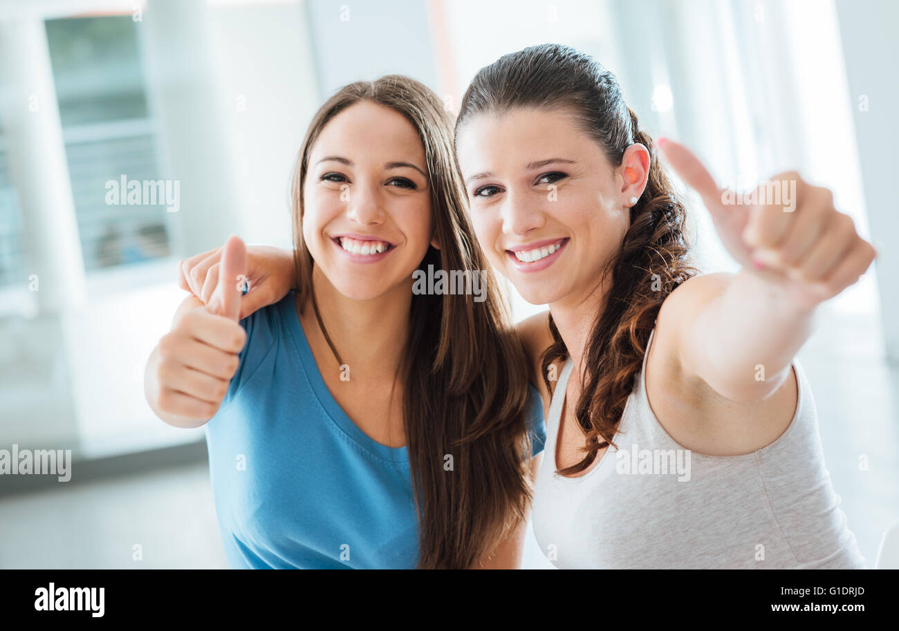 Allegro adolescente girls Thumbs up sorridente in telecamera, la gioventù e il concetto di divertimento Foto Stock