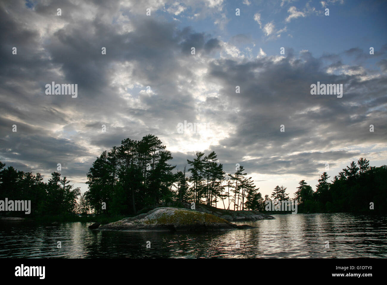 Altostratus nubi incombono sulla piccola isola di Chase Kabetogama sul lago in una calda serata estiva. Foto Stock