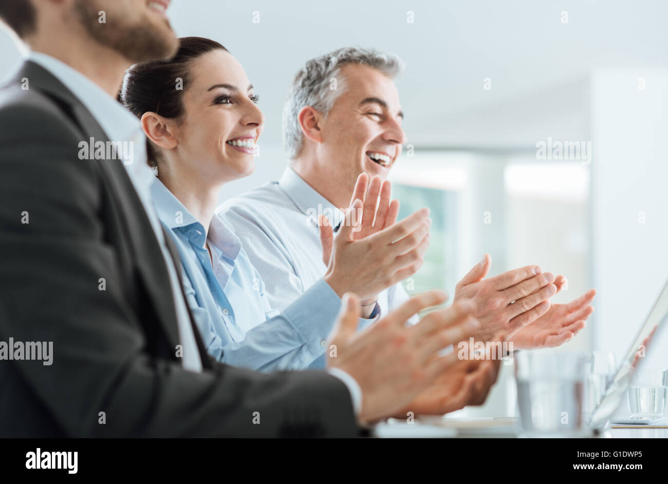 Allegro sorridente la gente di affari battendo le mani durante un seminario, il successo e il raggiungimento concept Foto Stock