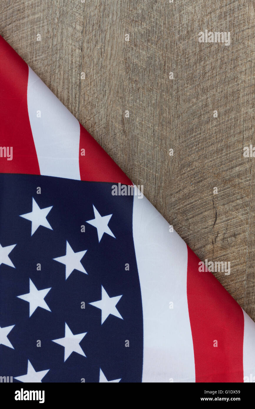 Frammento della bandiera americana ripiegata su legno tavolo in legno di noce. L'immagine verticale con copia spazio. Foto Stock