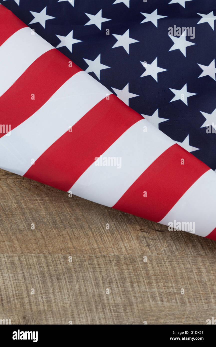 Frammento di bandiera degli Stati Uniti ripiegato su legno tavolo in legno di noce. L'immagine verticale con copia spazio. Foto Stock