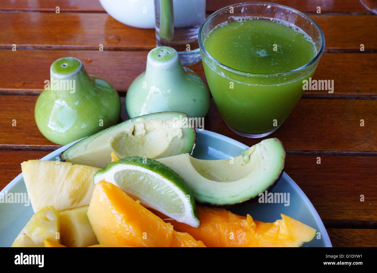 Una sana prima colazione con frutta fresca, avocado e succo verde Foto Stock