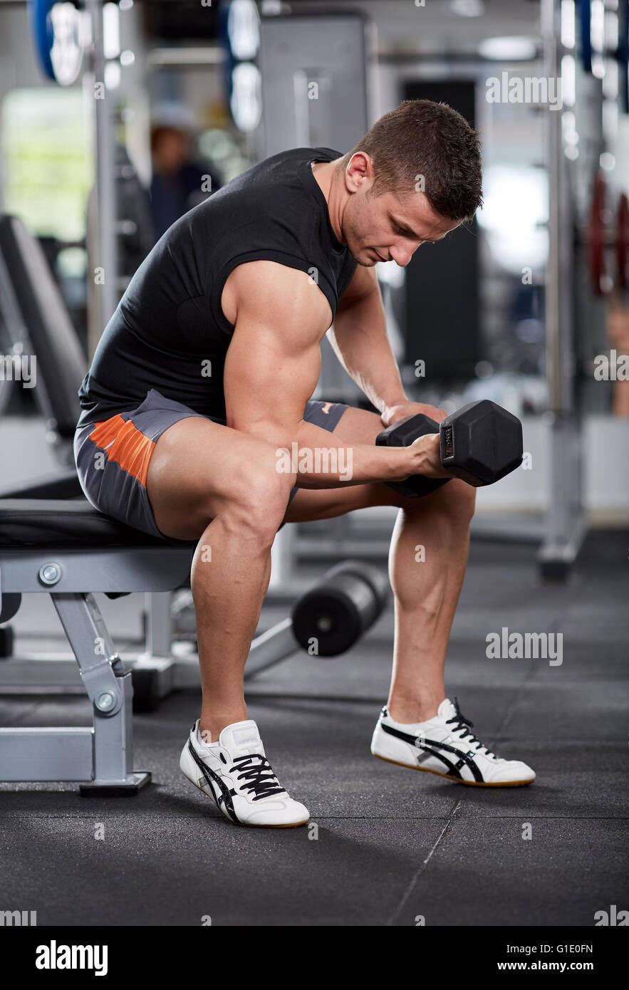 Athletic uomo facendo bicipite curl in posizione seduta in palestra Foto  stock - Alamy