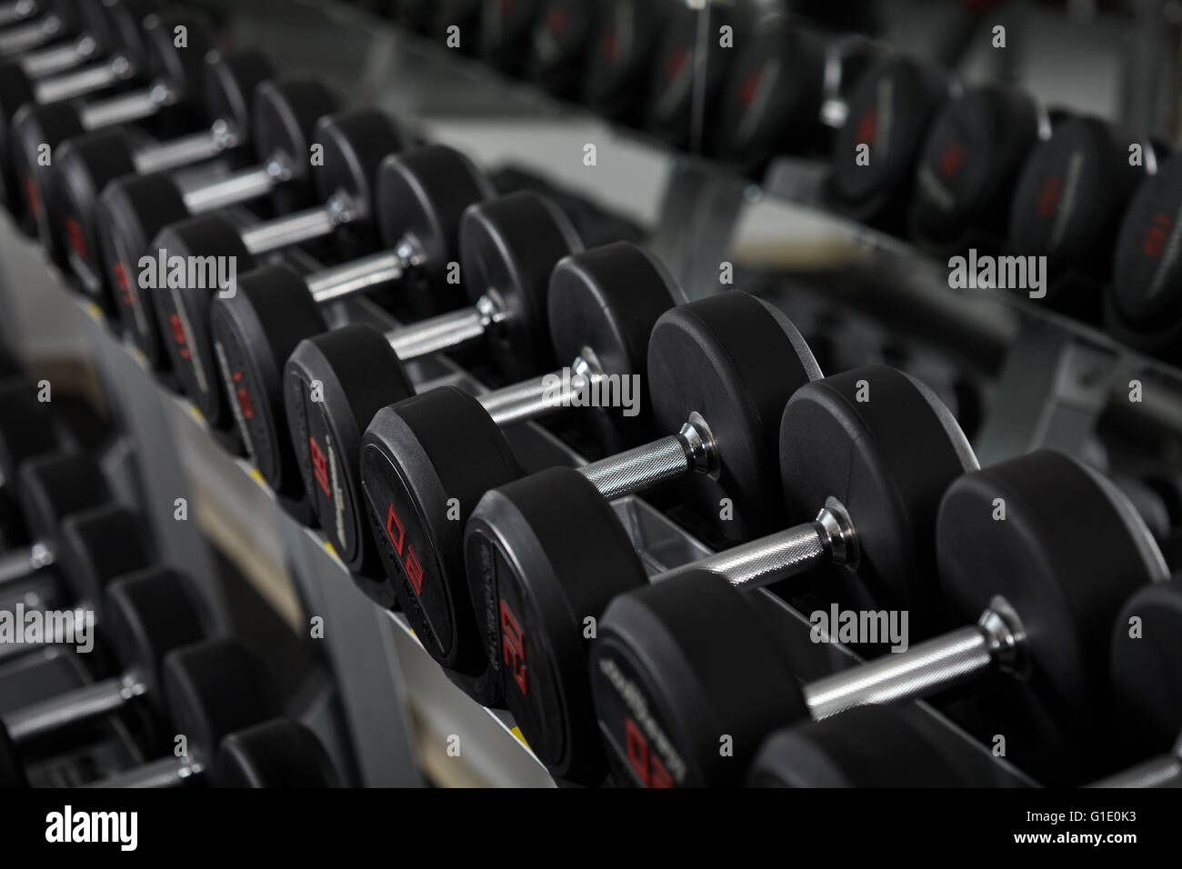 Righe di nuovi pesi nella palestra, sulla cremagliera Foto Stock