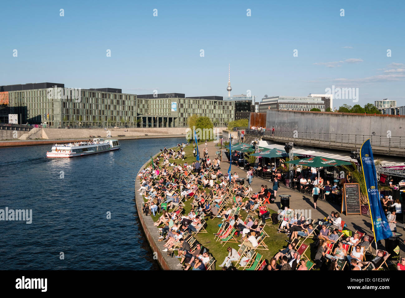 La gente seduta nel pomeriggio accanto al fiume Sprea a bar esterno a Berlino Germania Foto Stock