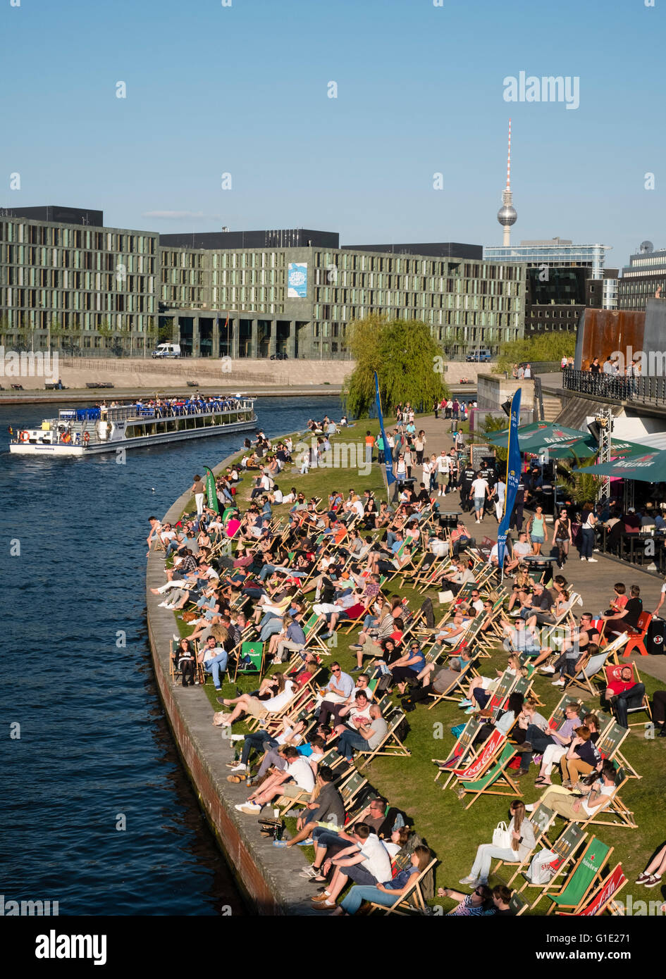 La gente seduta nel pomeriggio accanto al fiume Sprea a bar esterno a Berlino Germania Foto Stock