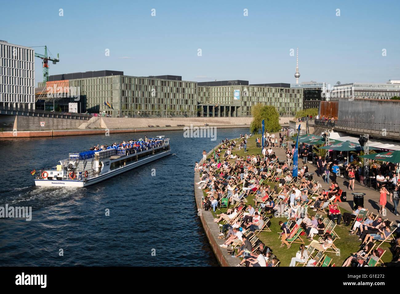 La gente seduta nel pomeriggio accanto al fiume Sprea a bar esterno a Berlino Germania Foto Stock