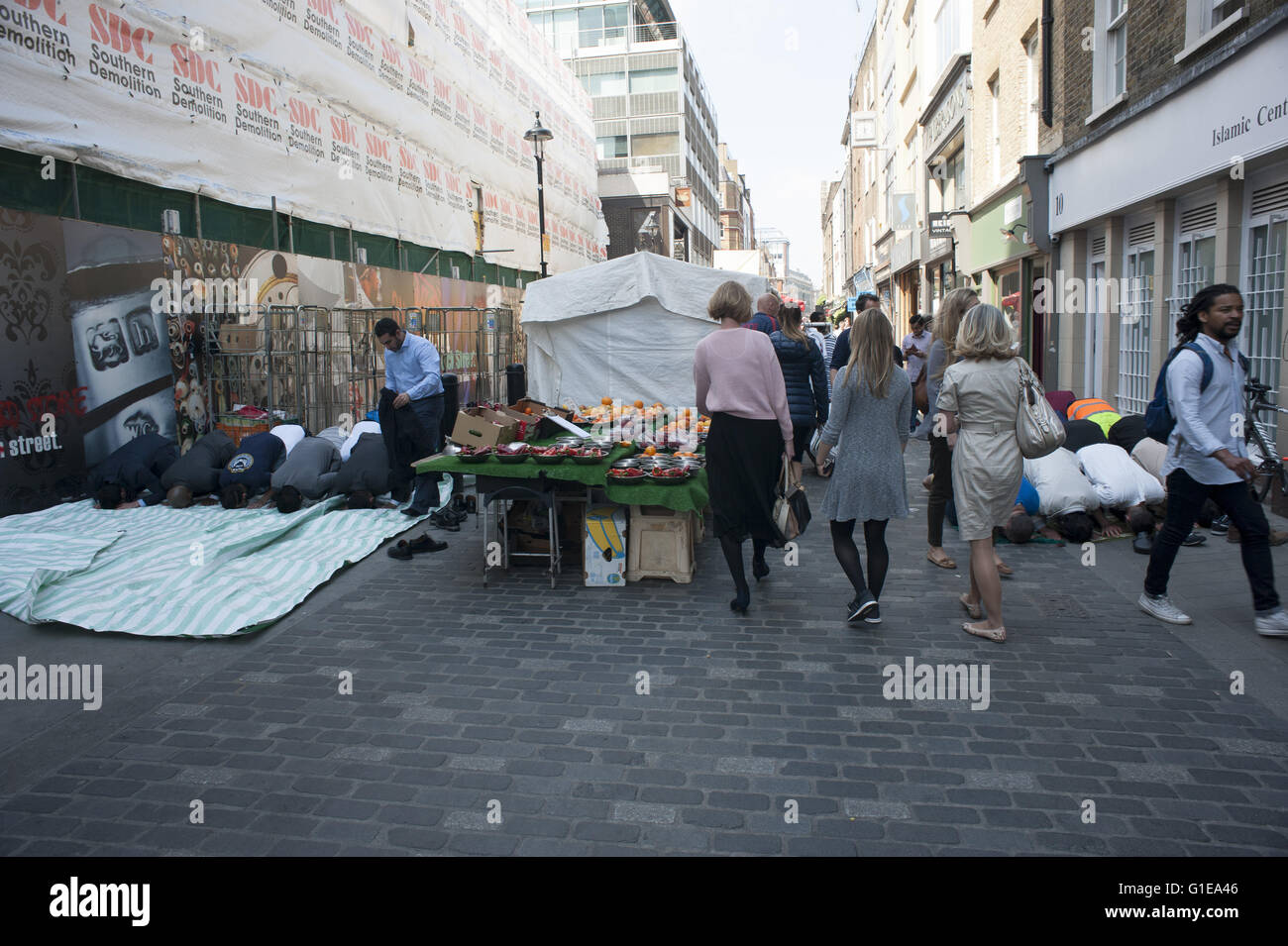 Londra, Regno Unito. 13 maggio 2016. Ufficio musulmano operai prendono parte a venerdì a mezzogiorno la preghiera in un central London street qui 13 maggio 2016. Consiglio di Westminster ha deciso questa settimana in mano il controllo di Berwick street market di Soho per un operatore privato. HUGH ALEXANDER/Alamy Live News Foto Stock