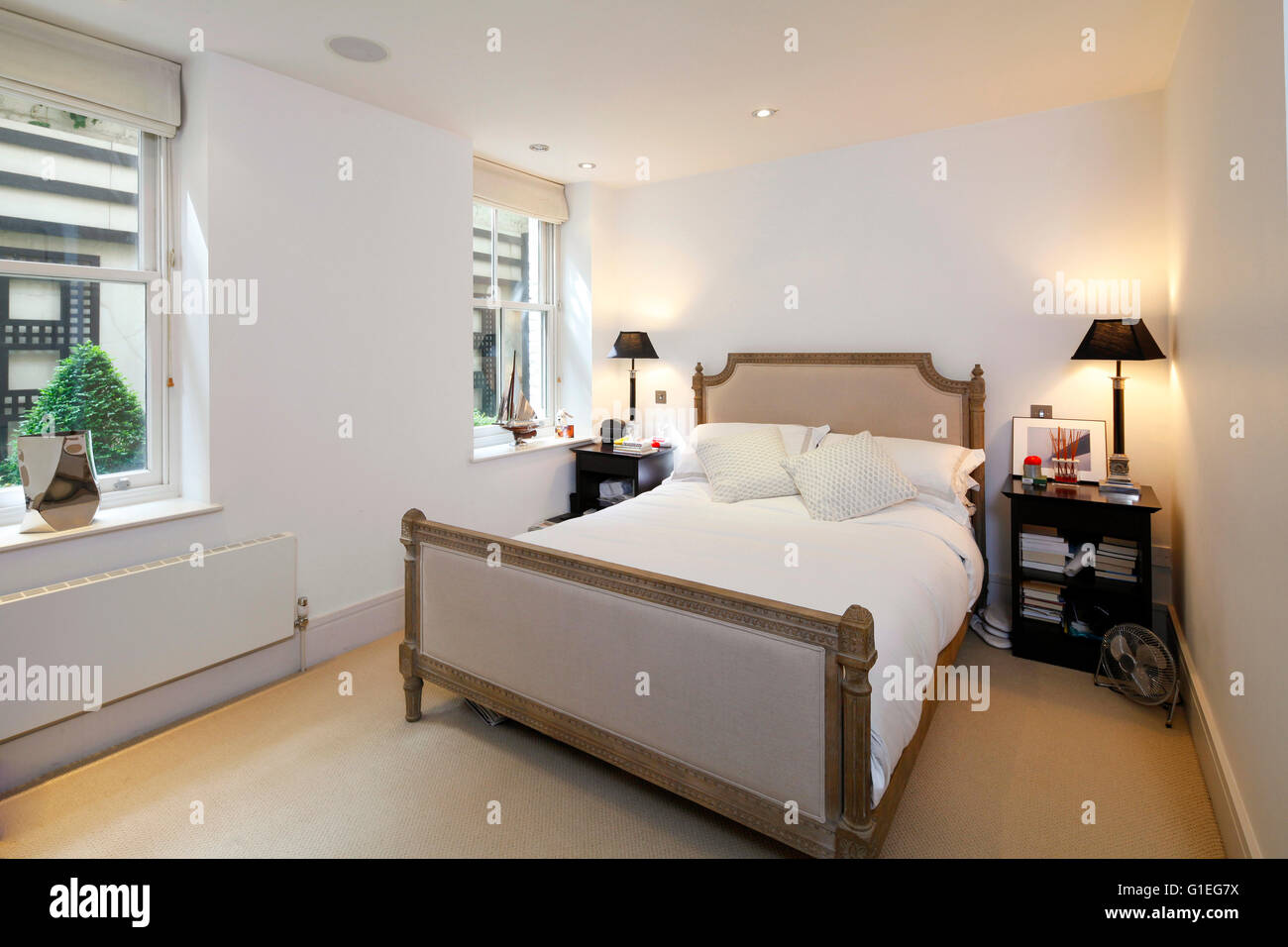 Bedford Gardens, Kensington. Camera da letto con pareti bianche e pavimenti in legno. Arredamento tradizionale. Foto Stock