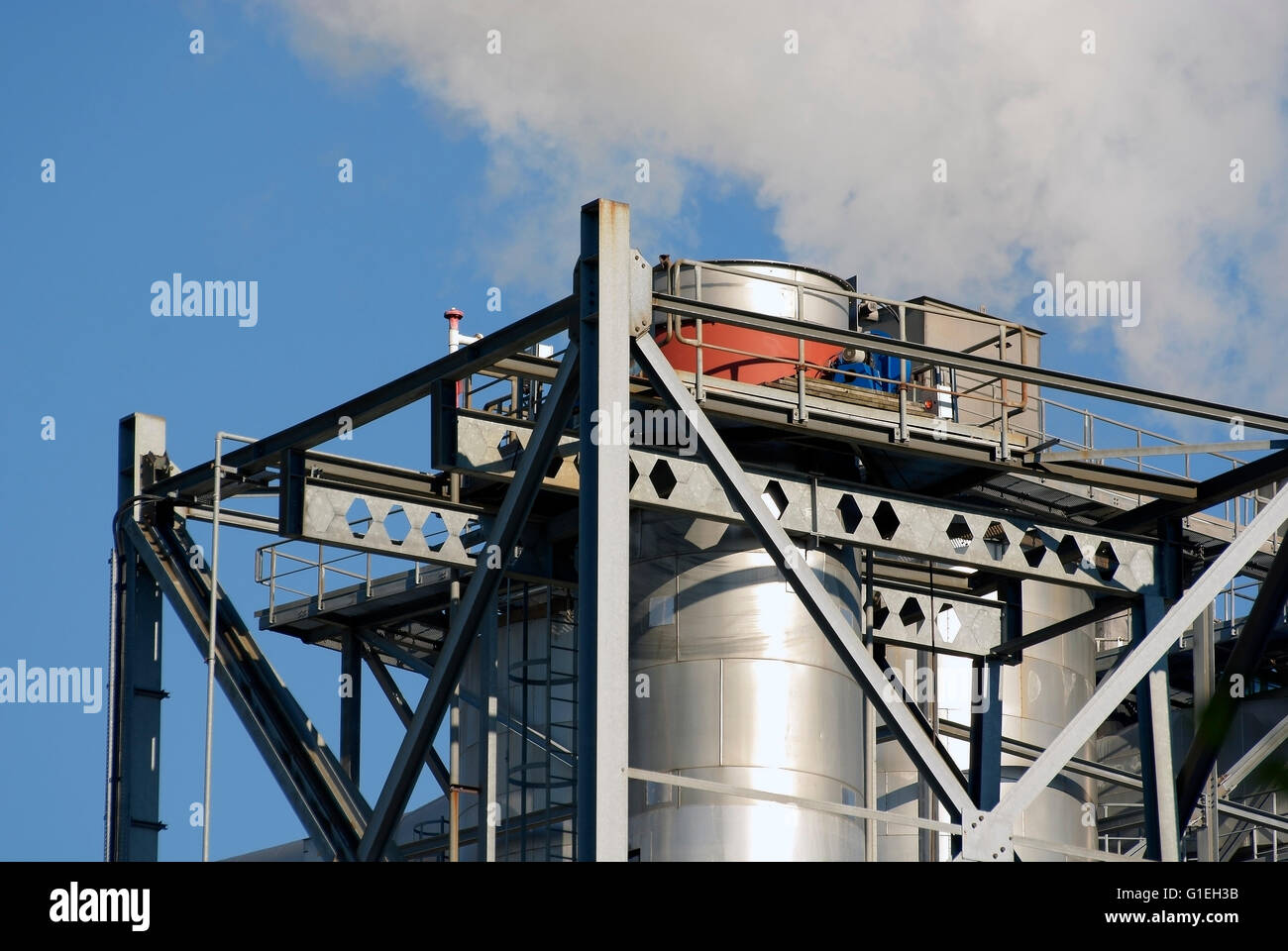 Camini industriali il rilascio di fumi in un blu cielo chiaro Foto Stock