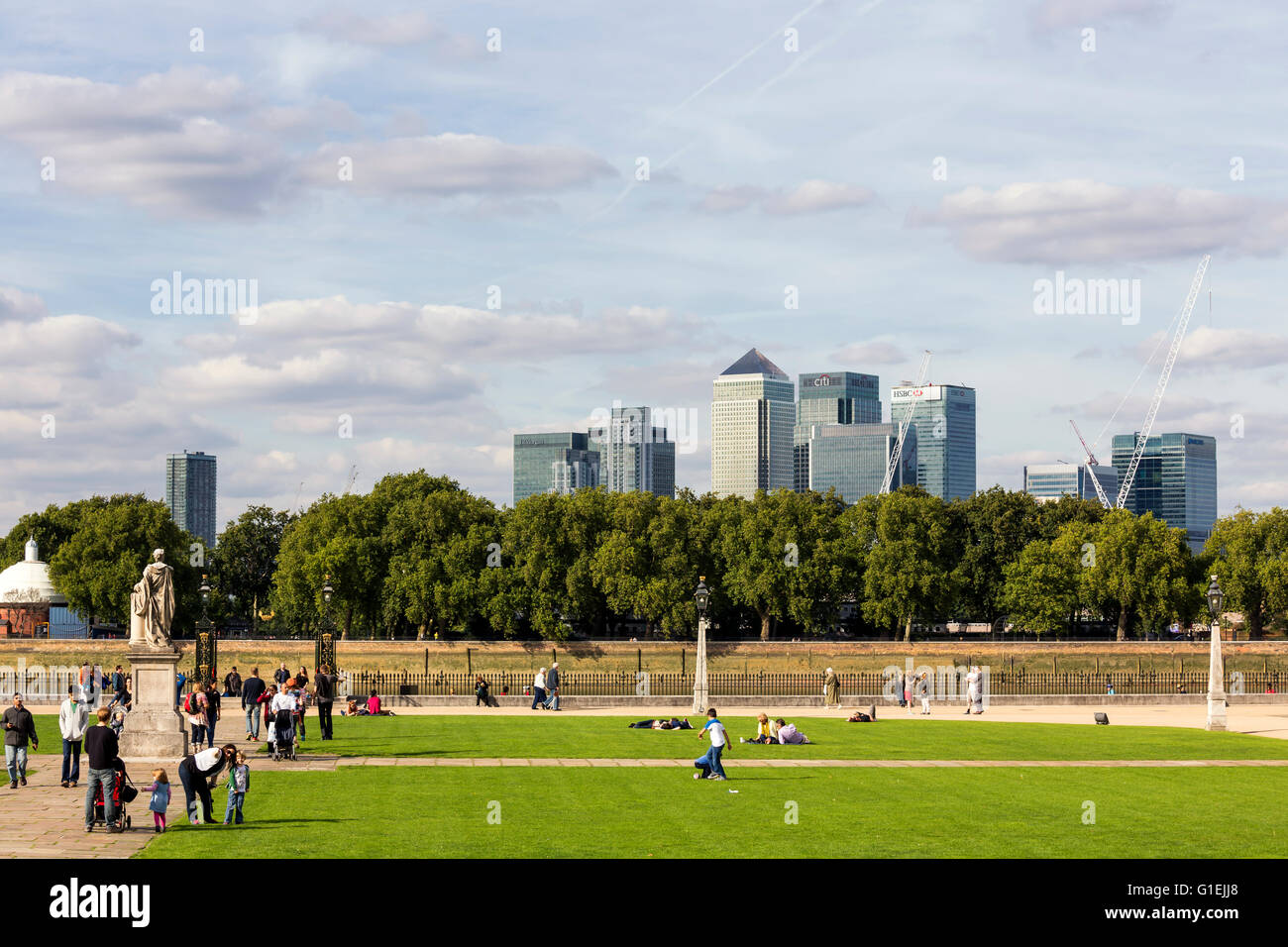 Le persone al di fuori del Royal Naval College con il punto di riferimento di edifici di Canary Wharf in background Foto Stock