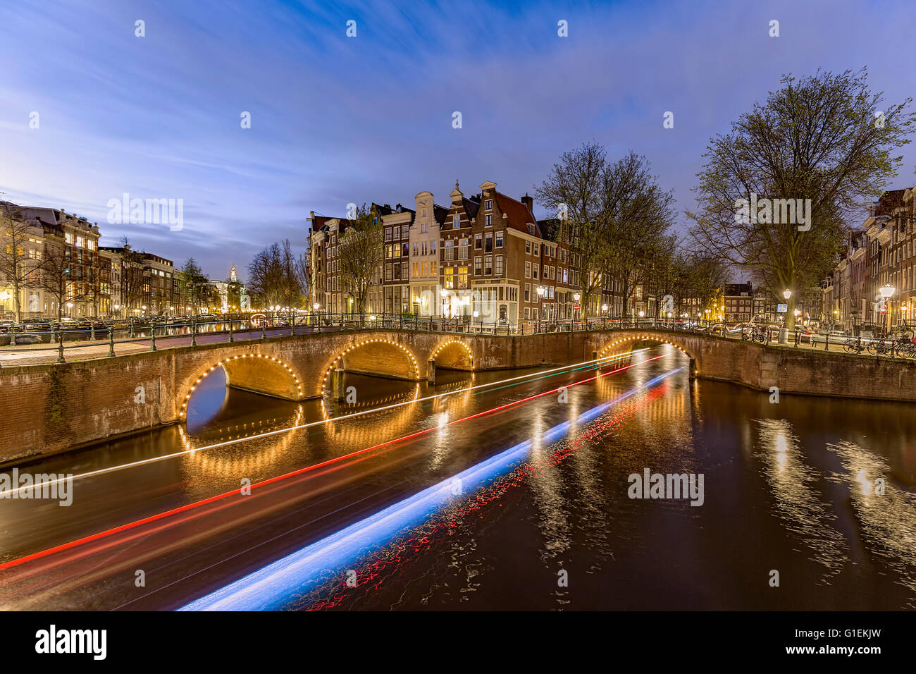 Vista tipica di Amsterdam canal scenario di notte con barca di raggi di luce durante la primavera e la stagione turistica, Amsterdam, Paesi Bassi Foto Stock