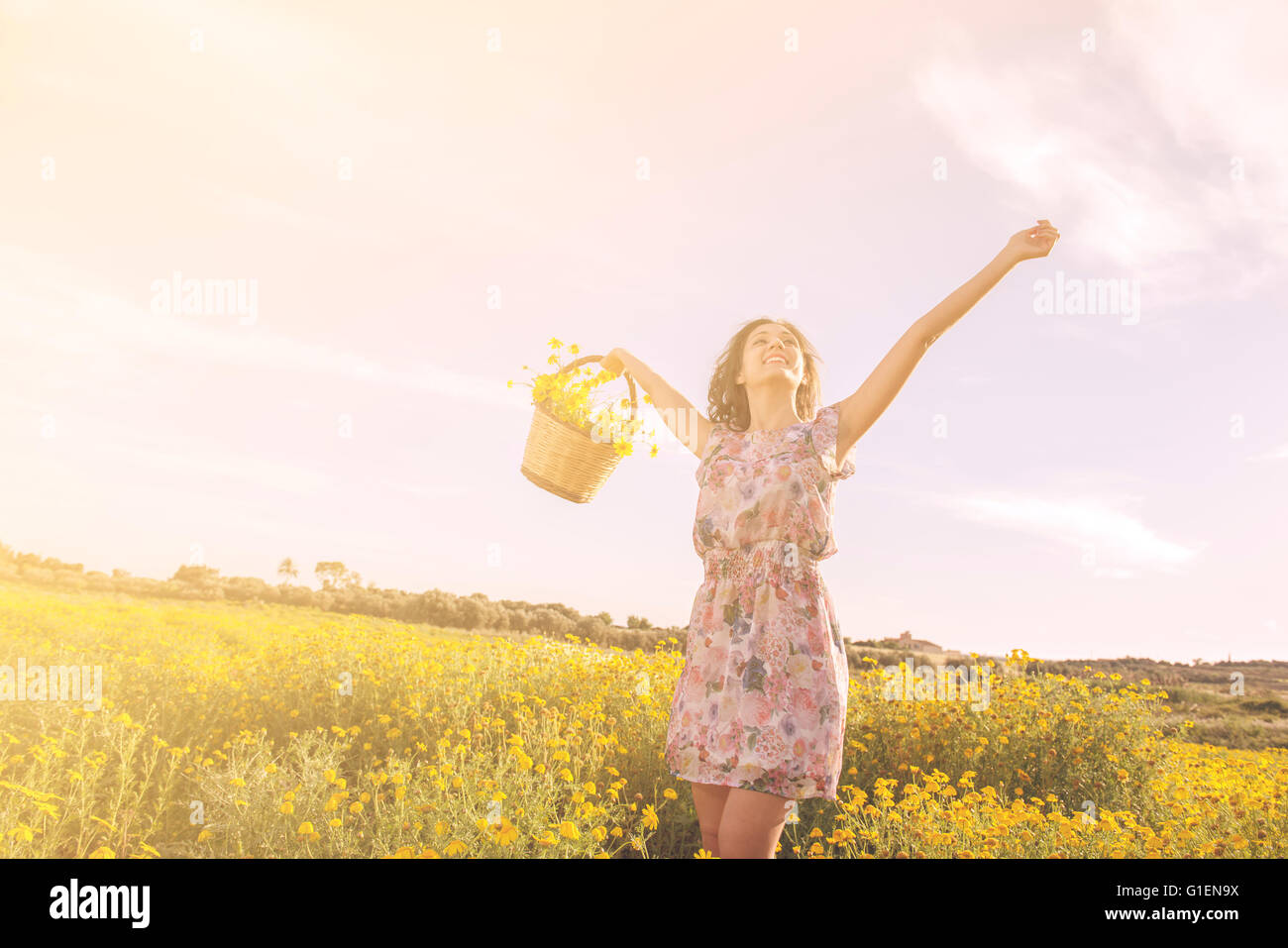 Ragazza ballando tra i fiori in una giornata di sole sotto un cielo blu Foto Stock