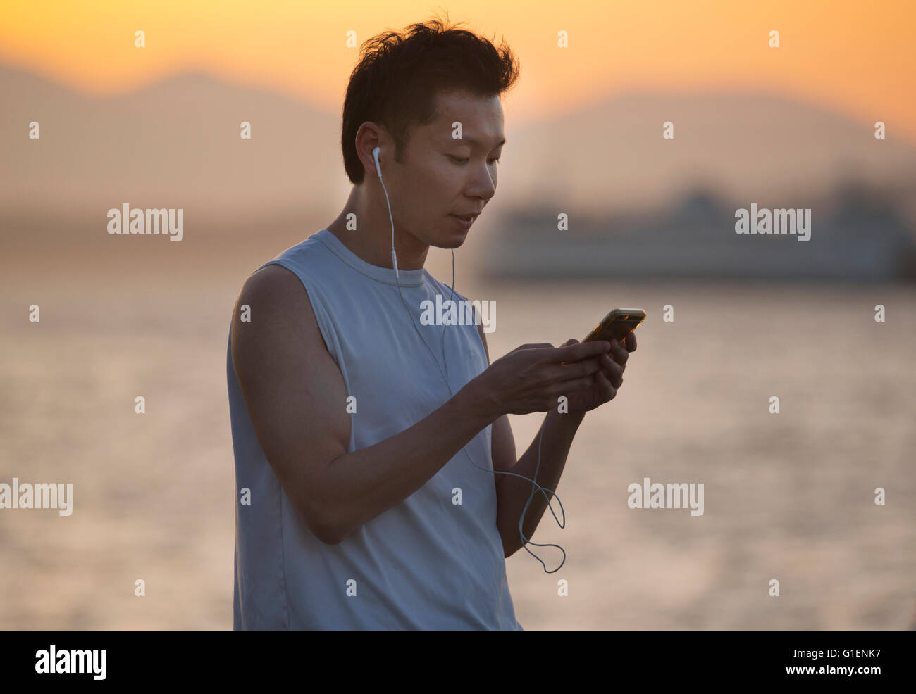 Il controllo della posta elettronica sul telefono, tramonto, Seattle, Puget Sound, Washington Foto Stock