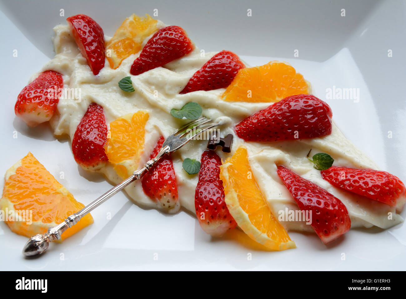 Gustosi dessert fatti di della pappa di miglio con frutti sulla piastra bianca con argento, vecchio, forcella vintage Foto Stock