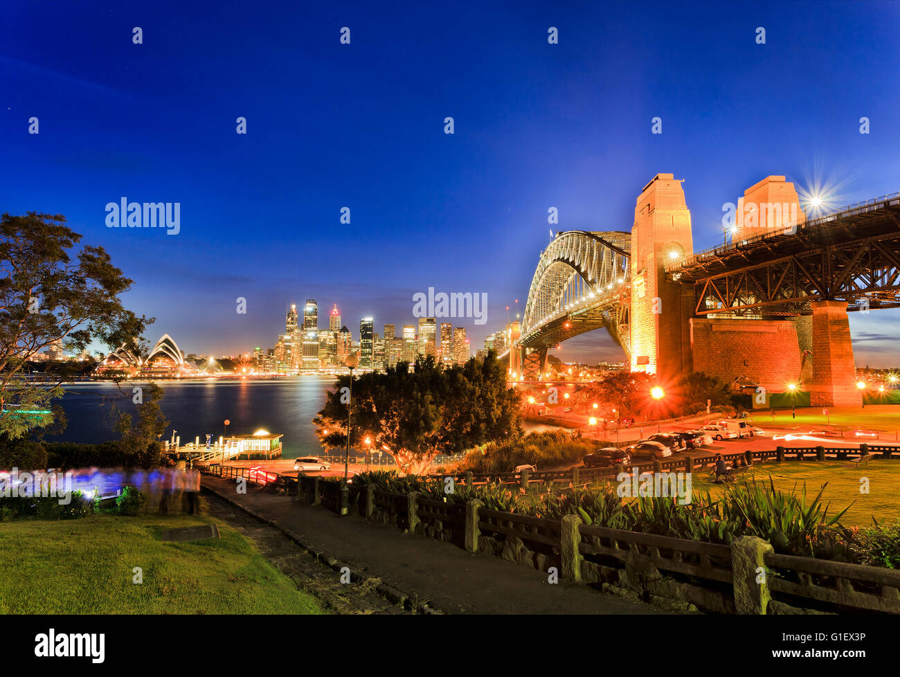Sydney importanti punti di riferimento della città al tramonto con illuminazione brillante e luci come visto da di Kirribilli oltre il porto. Ricco tramonto Foto Stock